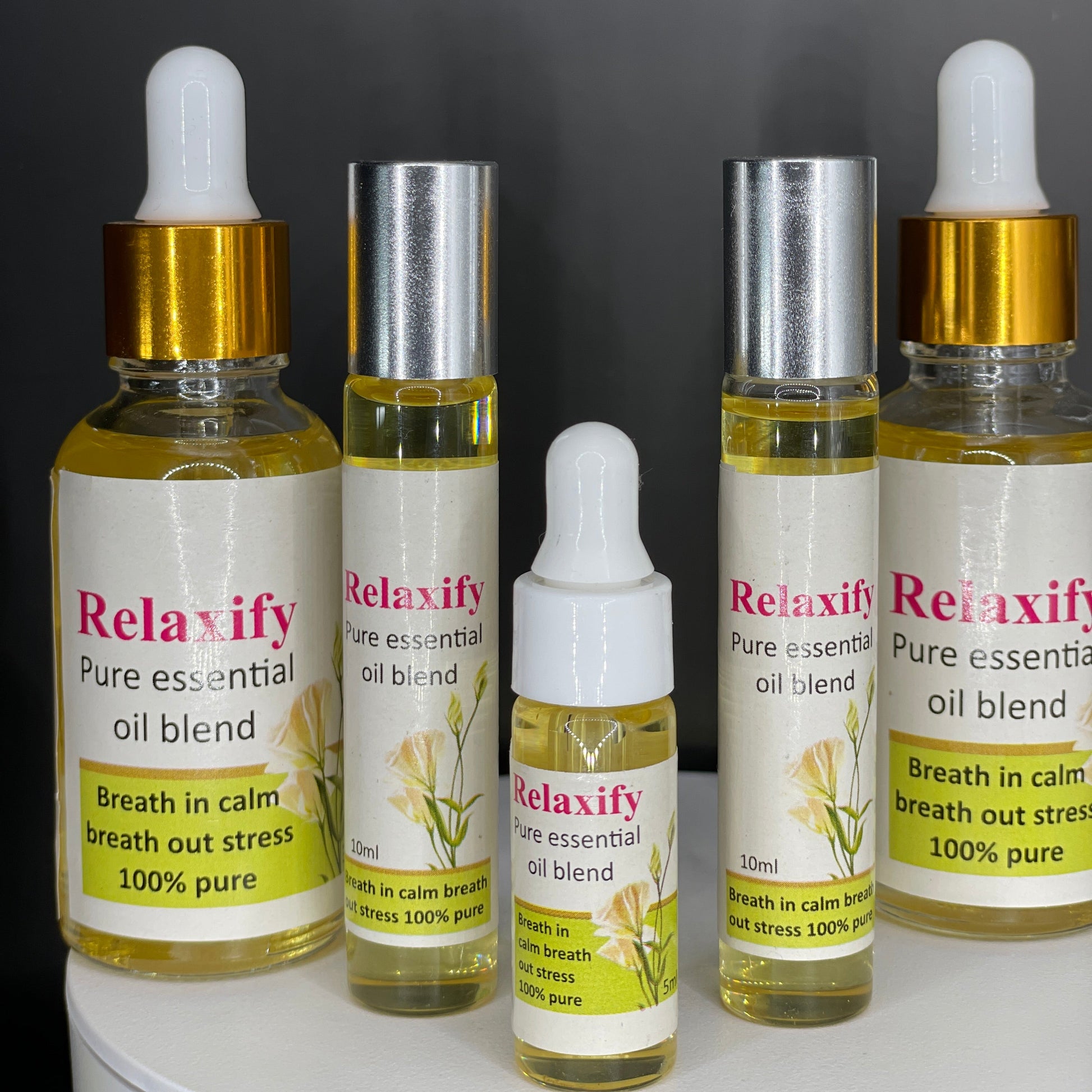 Five bottles of Relaxify pure essential oil blend on a gray background