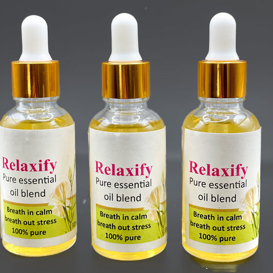 Three bottles of Relaxify pure essential oil blend on a dark background